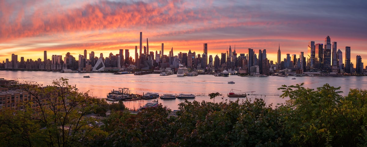 208 megapixels! A very high resolution panorama photo of the Manhattan skyline at sunrise with the Hudson River in the foreground and a vibrant, colorful sky of clouds; photograph created by Jeff Lewis from Weehawken, New Jersey of Midtown Manhattan, New York City.